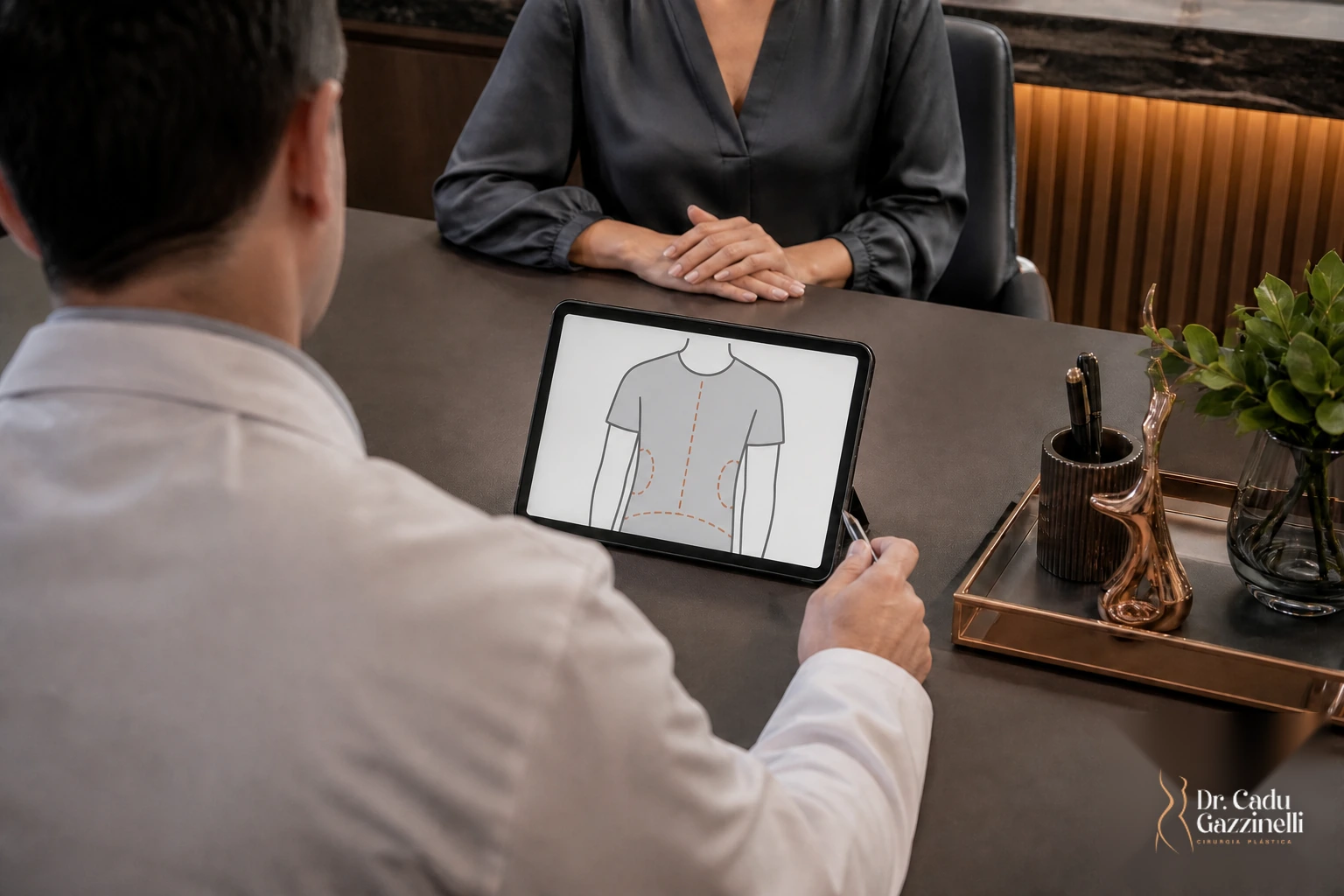 Consulta médica em consultório: cirurgião conversa com paciente usando um diagrama de contorno corporal em um tablet