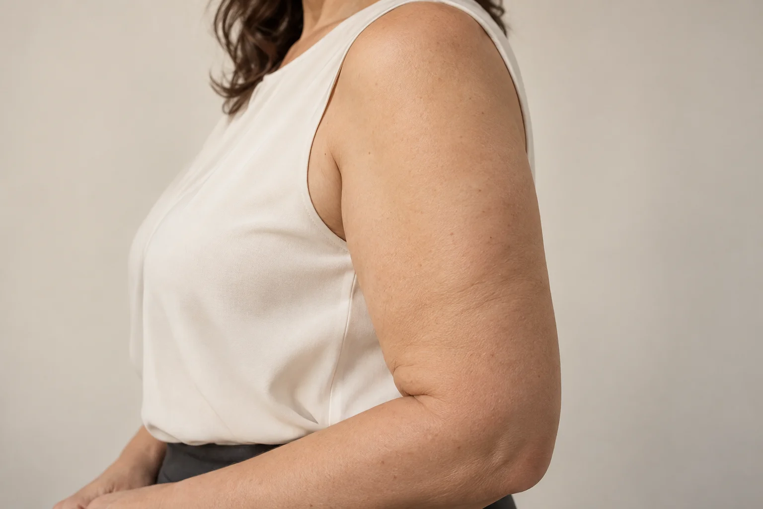 Braço de mulher adulta fictícia com blusa sem mangas